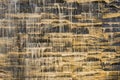 Falling water stream against stonework rough texture