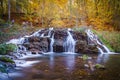 Falling waterfall surrounded by autumn trees