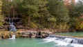 Falling waterfall surrounded by dense trees