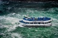 Falls boat tour ship with tourists moves to Niagara falls Royalty Free Stock Photo