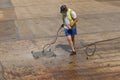 Man scrubbing clean a slipway at Falmouth Harbour, UK