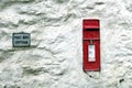 Falmouth, Cornwall, UK - April 12 2018: A traditional British Royal Mail Post Office post box, set into a rough rustic white wall