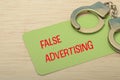False Advertising and Legal Consequences: Open Handcuffs on Warning Card Royalty Free Stock Photo