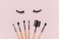False eyelashes and a set of makeup brushes on a pink background Royalty Free Stock Photo
