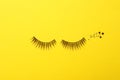 False eyelashes and sparkles on yellow background Royalty Free Stock Photo