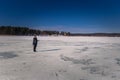 Falun - March 31, 2018: Traveler hiking on the frozen lake at Framby Udde near the town of Falun in Dalarna, Sweden