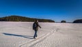 Falun - March 31, 2018: Traveler hiking on the frozen lake at Framby Udde near the town of Falun in Dalarna, Sweden