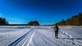 Falun - March 31, 2018: Traveler hiking on the frozen lake at Framby Udde near the town of Falun in Dalarna, Sweden