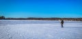 Falun - March 31, 2018: Traveler hiking on the frozen lake at Framby Udde near the town of Falun in Dalarna, Sweden