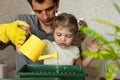 Famaliy dad and daughter plant indoor flowers at home Royalty Free Stock Photo