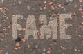 Fame written in white capital letters on a street pavement