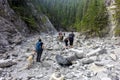 Families hiking the Grotto Canyon trail with inukshuks built all round outside Canmore, Alberta, Canada.