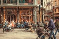 Families with kids meeting on streets, talking and drinking at outdoor bar with vintage furniture at evening