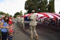 Families watch the US flag go by at a fourth of July parade.