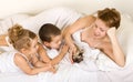 Familiy playing with a little kitten laying in bed Royalty Free Stock Photo