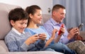Family absorbedly looking at smartphones Royalty Free Stock Photo