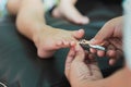 Family activity concept. Mother hand cutting pedicure nails for kid by using nail clipper Royalty Free Stock Photo