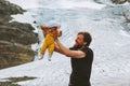 Family adventure father holding up baby climbing in glacier mountains