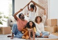 A family affair. a young family holding up a cardboard box to form a roof at home. Royalty Free Stock Photo