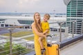 Family at airport before flight. Mother and son waiting to board at departure gate of modern international terminal Royalty Free Stock Photo