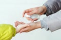 Family applying hand sanitizer to clean and disinfect hands. Woman applying alcohol spray against coronavirus. Mother and son