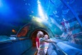 Family in aquarium. Kids watch fish, marine life