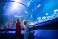 Family in aquarium. Kids watch fish, marine life