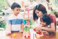 Family with asian mother and children playing toy block at home, mom and son and daughter doing activity and hobby.