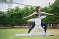 Family Asian Mother teacher training yoga child daughter on a yoga mat at home garden. Family outdoors. Parent with child spends