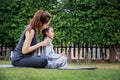 Family Asian Mother teacher training yoga child daughter on a yoga mat at home garden. Family outdoors. Parent with child spends