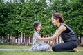 Family Asian Mother teacher training yoga child daughter on a yoga mat at home garden. Family outdoors. Parent with child spends