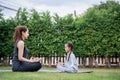 Family Asian Mother teacher training yoga child daughter on a yoga mat at home garden. Family outdoors. Parent with child spends