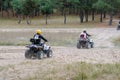 A family ATV ride through an autumn woodland. Husband, wife and