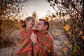 Family autumn walking. Cute girl with her father wrapping up in plaid among golden forest at fall