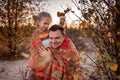 Family autumn walking. Cute girl with her father wrapping up in plaid among golden forest at fall