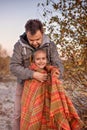 Family autumn walking. Cute girl with her father wrapping up in plaid among golden forest at fall