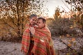 Family autumn walking. Cute girl with her father wrapping up in plaid among golden forest at fall