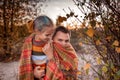 Family autumn walking. Cute girl with her father wrapping up in plaid among golden forest at fall