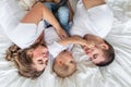 Family with baby in bed, kissing and hugging kid Royalty Free Stock Photo