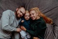 Family with baby in bed, kissing and hugging kid Royalty Free Stock Photo