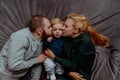 Family with baby in bed, kissing and hugging kid Royalty Free Stock Photo