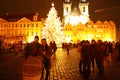 Family with baby by Christmas tree on Old Town Square in Prague at night