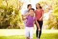 Family With Baby In Carrier Walking Through Park Royalty Free Stock Photo