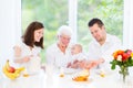 Family with baby having breakfast with drandmother