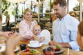Family with baby in high chair eating food at restaurant. Royalty Free Stock Photo