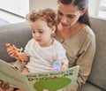 Family, baby and reading a book with a mother and boy child on a sofa in the living room of home together. Education Royalty Free Stock Photo