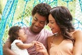 Family With Baby Relaxing On Outdoor Garden Swing Seat Royalty Free Stock Photo