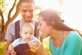 Family With Baby Son In Carrier Walking Through Park Royalty Free Stock Photo