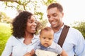 Family With Baby Son In Carrier Walking Through Park Royalty Free Stock Photo