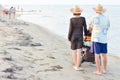 Family with baby stroller walking on sandy beach Royalty Free Stock Photo